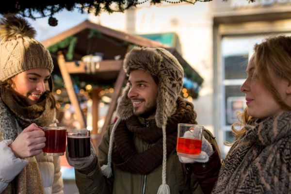 Drei Personen trinken gemeinsam einen Glühwein