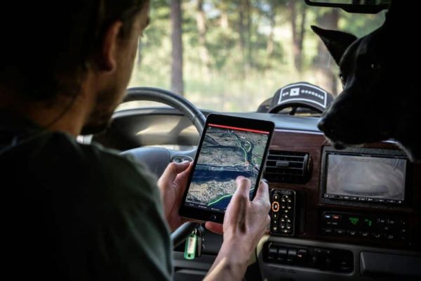 Mann schaut eine Karte auf einem Tablet im Auto an