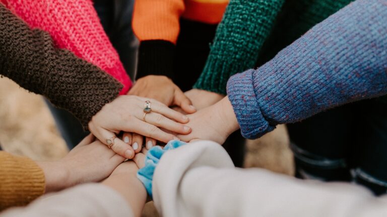 Mehrere Hände symbolisieren eine Teambuilding Agentur