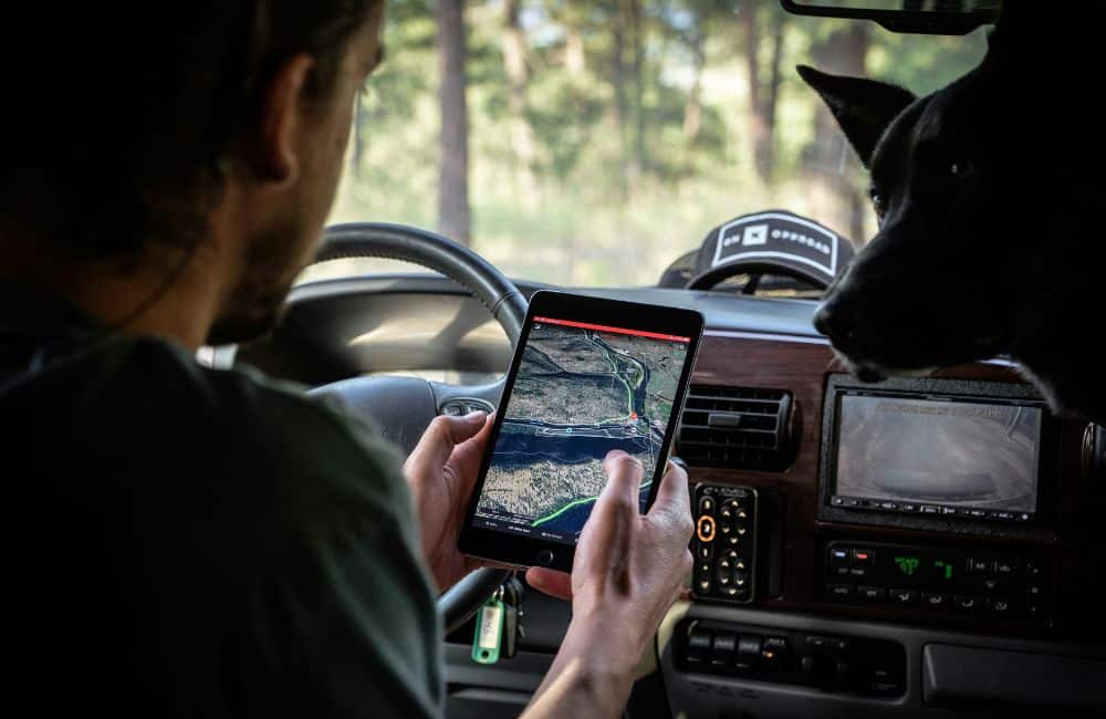 Mann sitzt im Auto und schaut auf ein Tablet