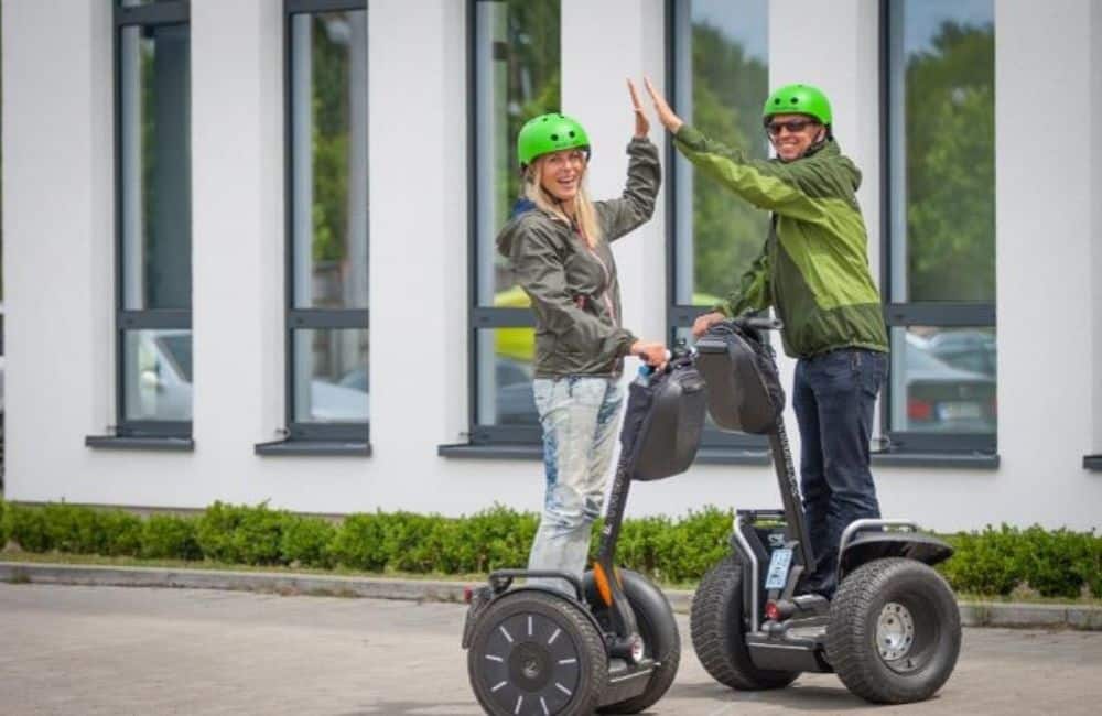 2 Personen geben sich High Five auf Segways