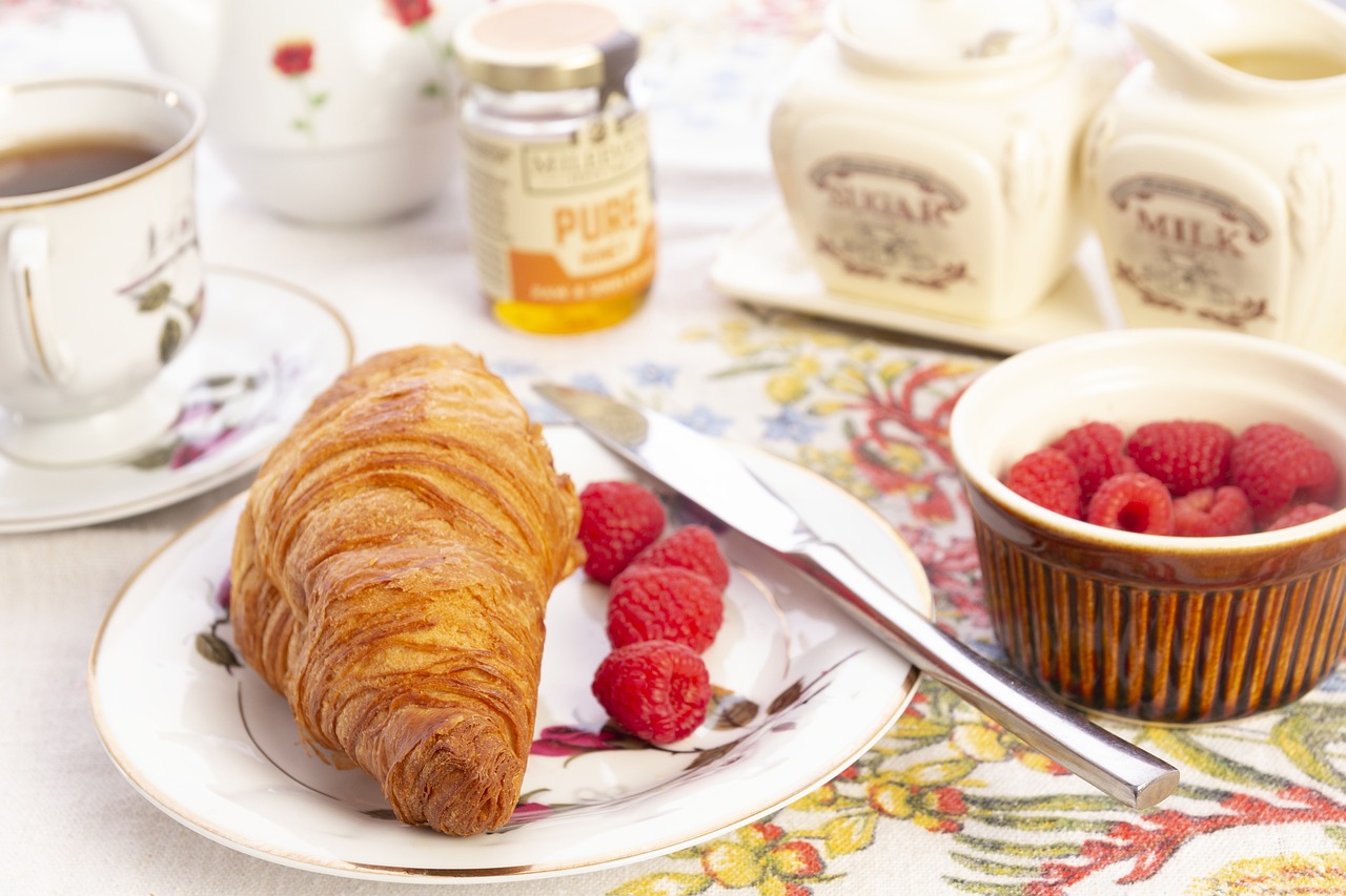 Frühstück mit Croissant, Himbeeren und Kaffee bei einer Incentive-Reise